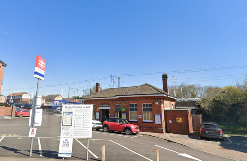 Knebworth train station and car park with a few cars parked in it.