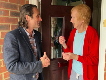 Alex Clarkson talking to a lady on her doorstep.