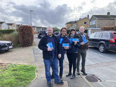 Alex Clarkson with the Conservative Candidates for Bandley Hill & Poplars Ward. They are stood in a residential road with houses and cars in the background.